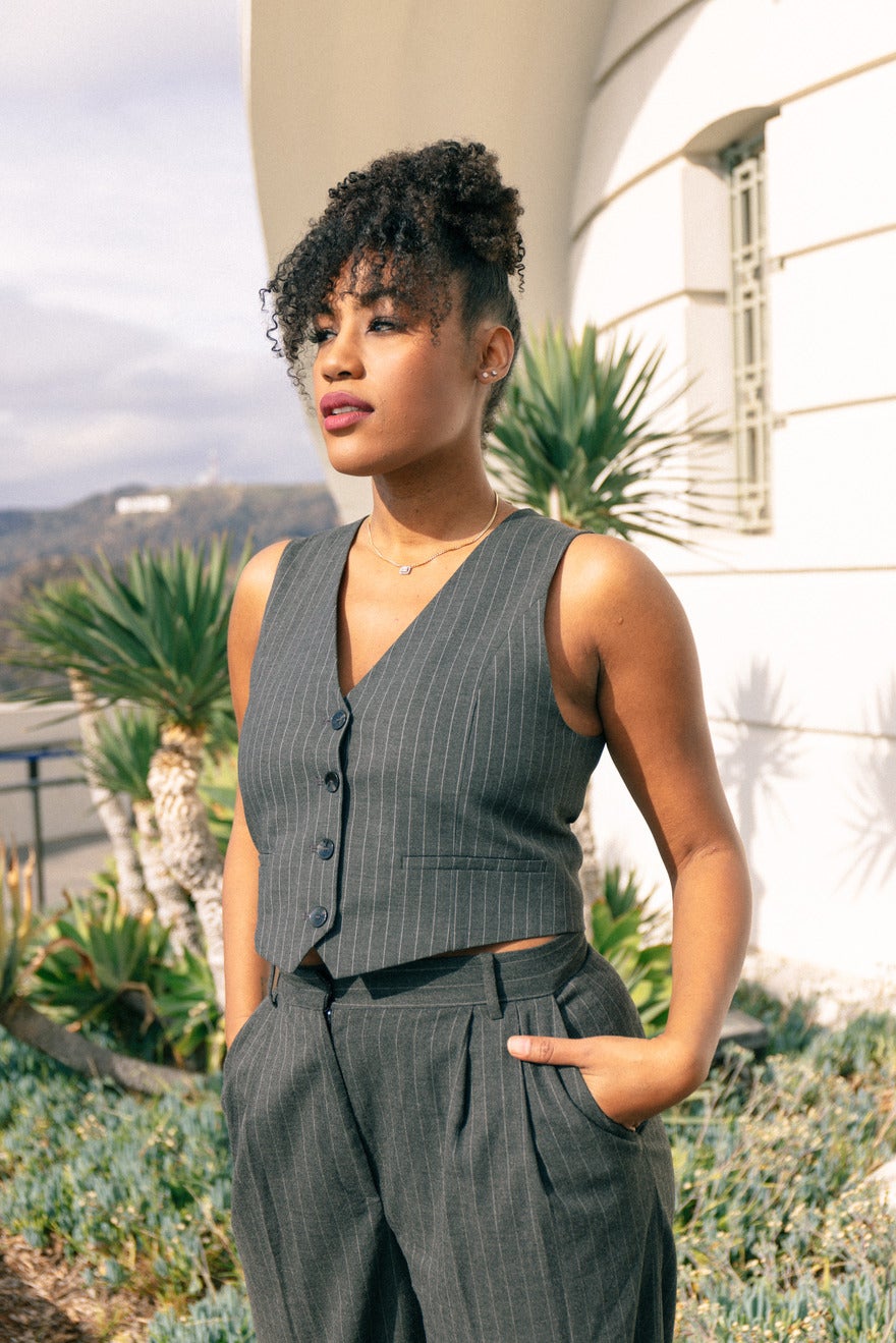 Shontel Horne standing in front of palm trees wearing a grey suit